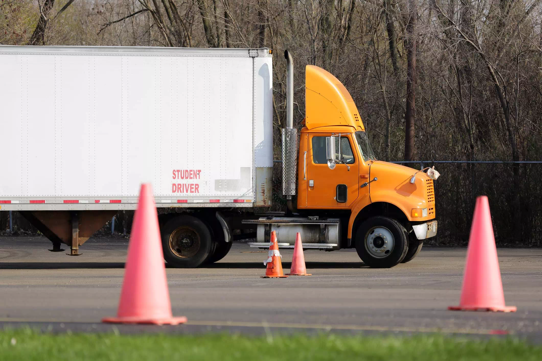 pomarańczowa ciężarówka z białą naczepą